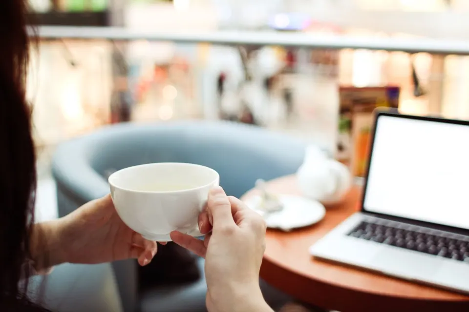 MacBook đặt trên bàn quán cà phê