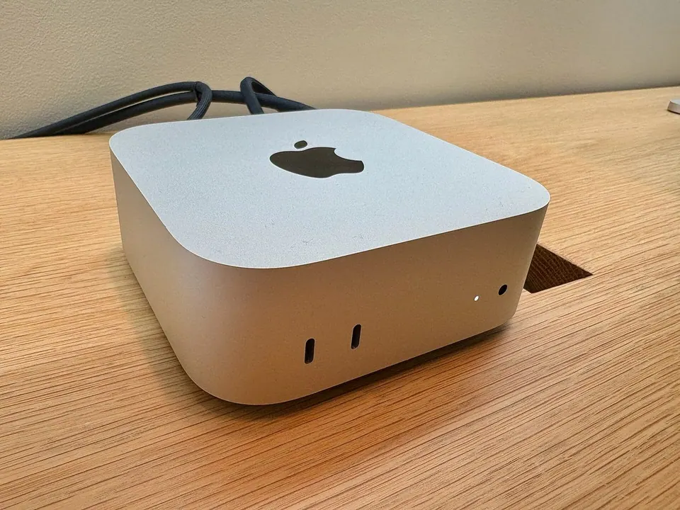 Mac mini M4 đặt trên bàn gỗ, cắm cáp phía sau